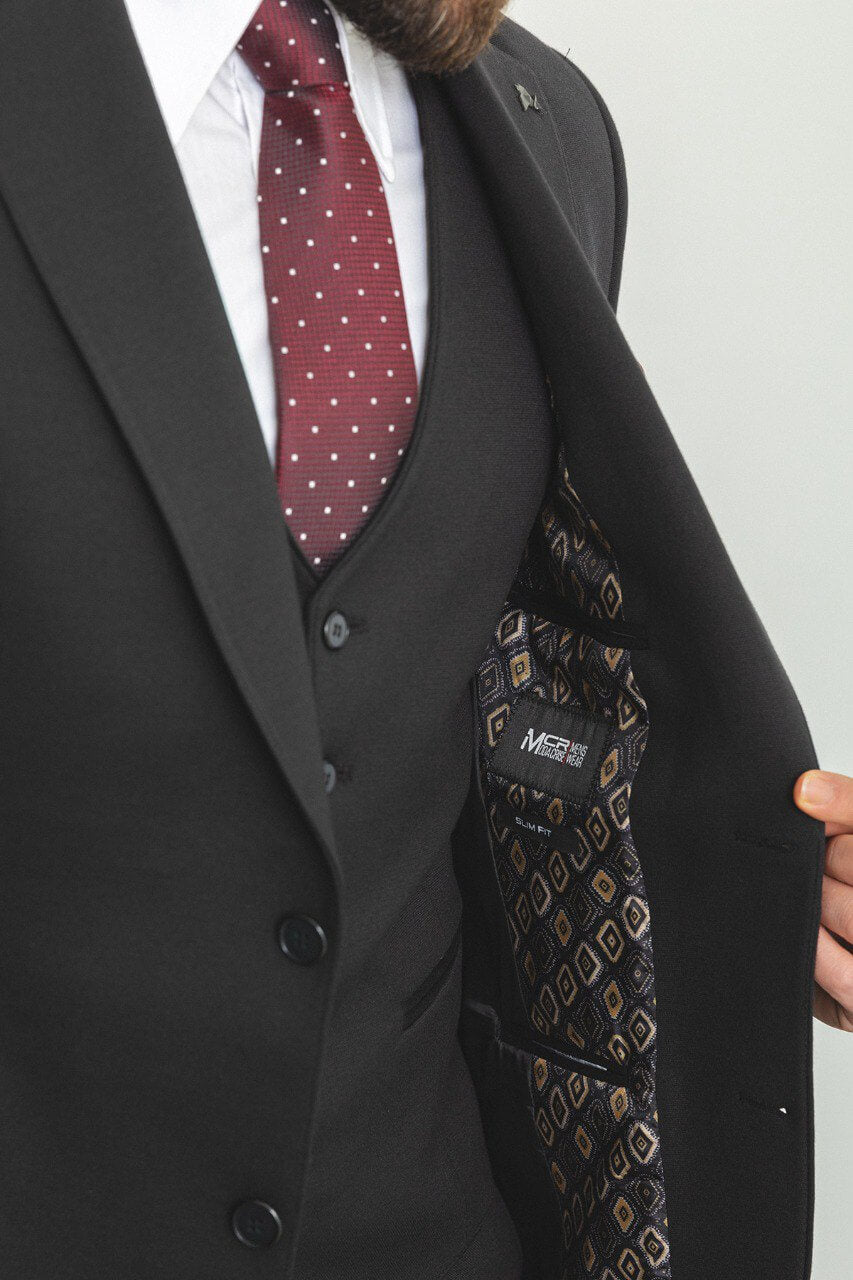 Man in a black 3-piece suit with a burgundy tie and pocket square.