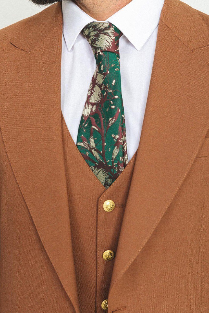 Man wearing a camel 3-piece suit with a white shirt and patterned tie.