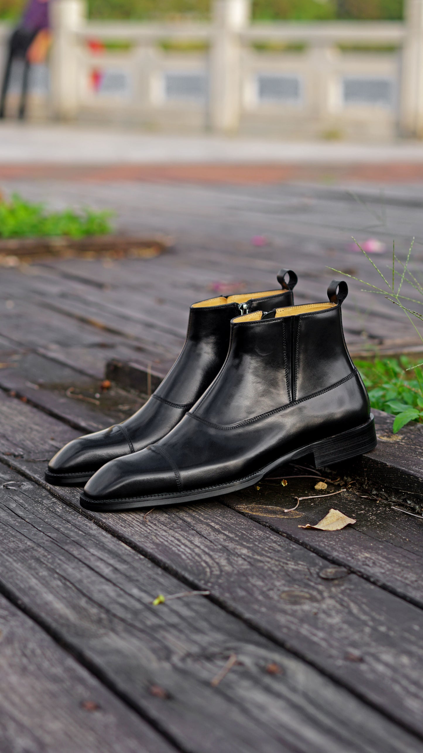 A pair of polished black leather Chelsea boots with a sleek design, ideal for formal wear and business occasions.