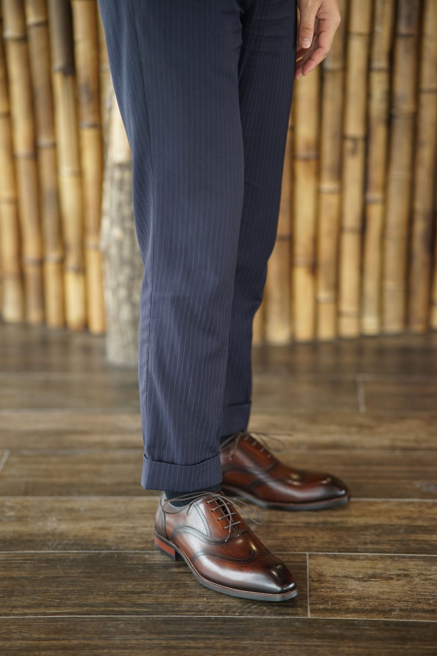 A pair of handcrafted brown leather oxford shoes with wingtip detailing, showcasing elegant design and premium craftsmanship.