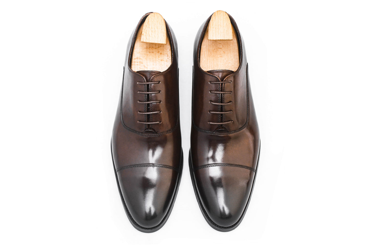 Close-up of men's espresso brown leather oxford shoes with a cap-toe design.