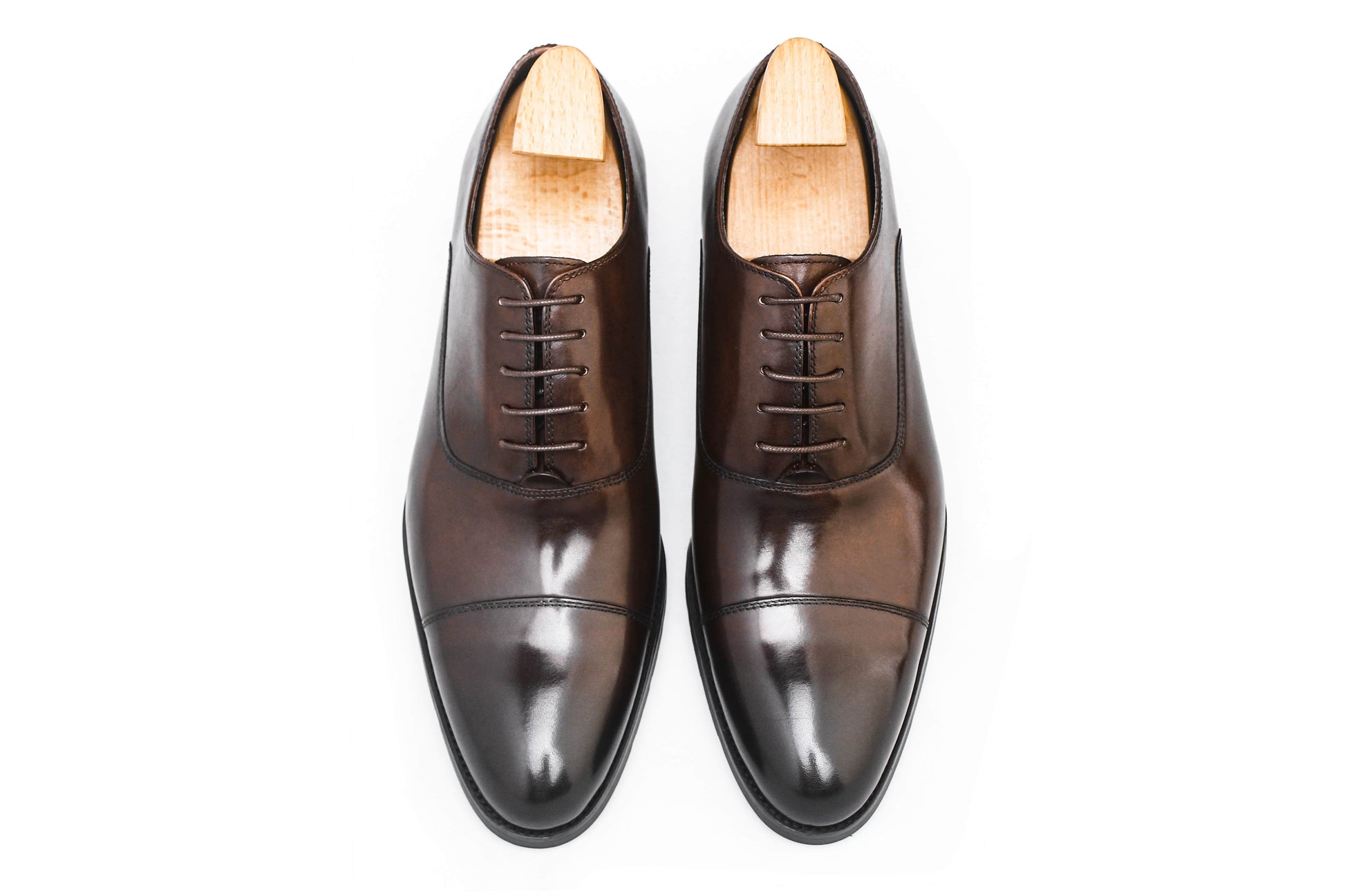 Close-up of men's espresso brown leather oxford shoes with a cap-toe design.