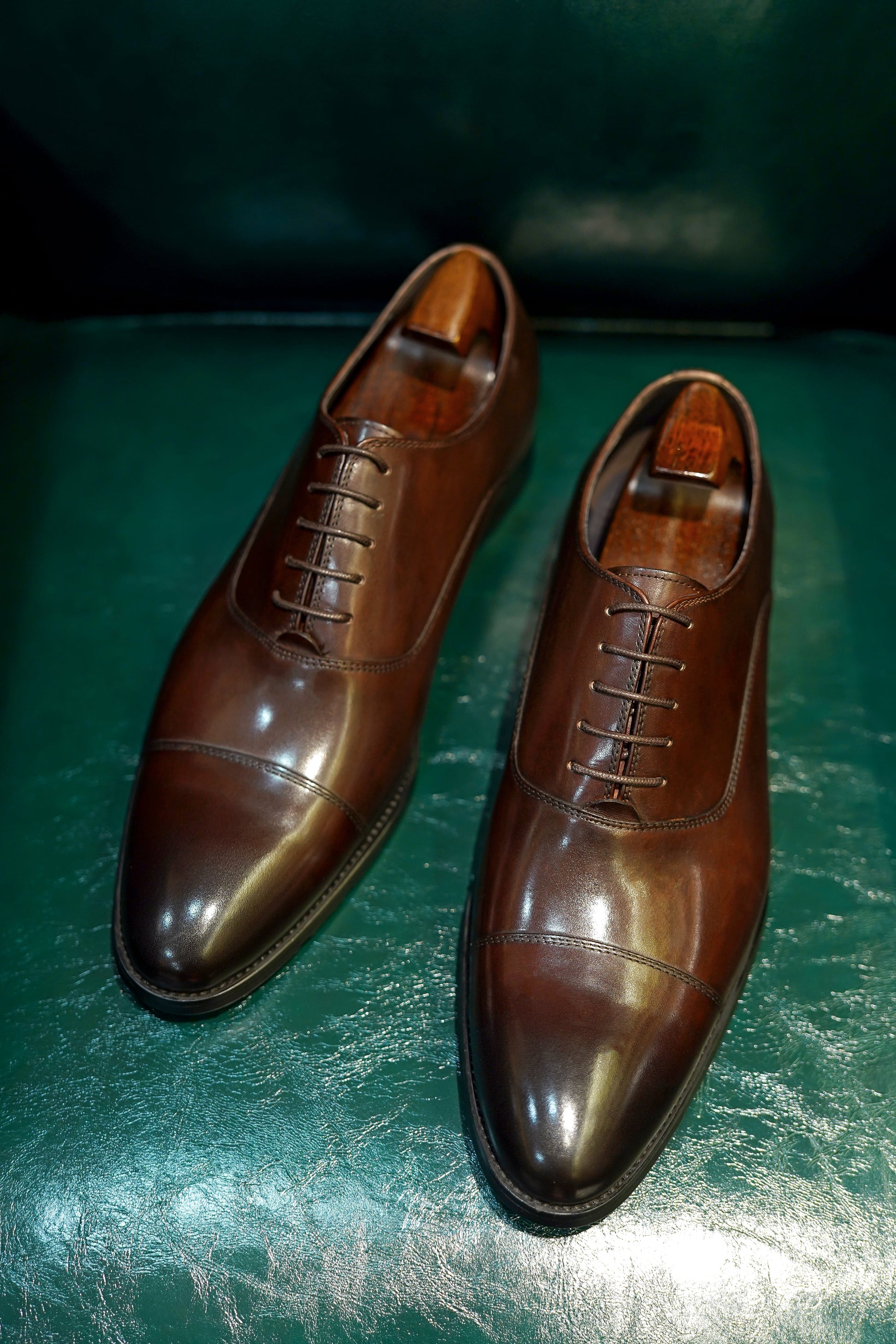 Close-up of men's espresso brown leather oxford shoes with a cap-toe design.