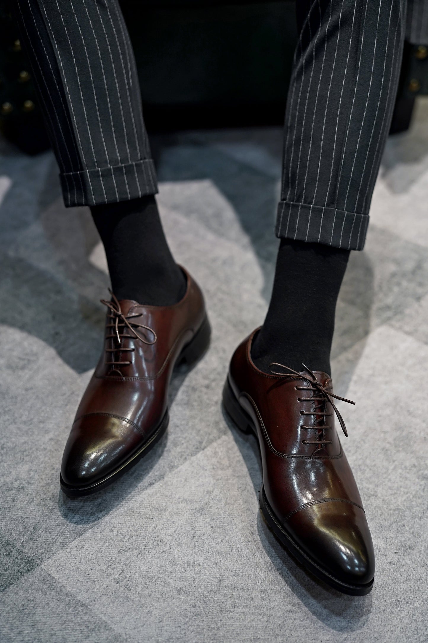 Close-up of men's espresso brown leather oxford shoes with a cap-toe design.
