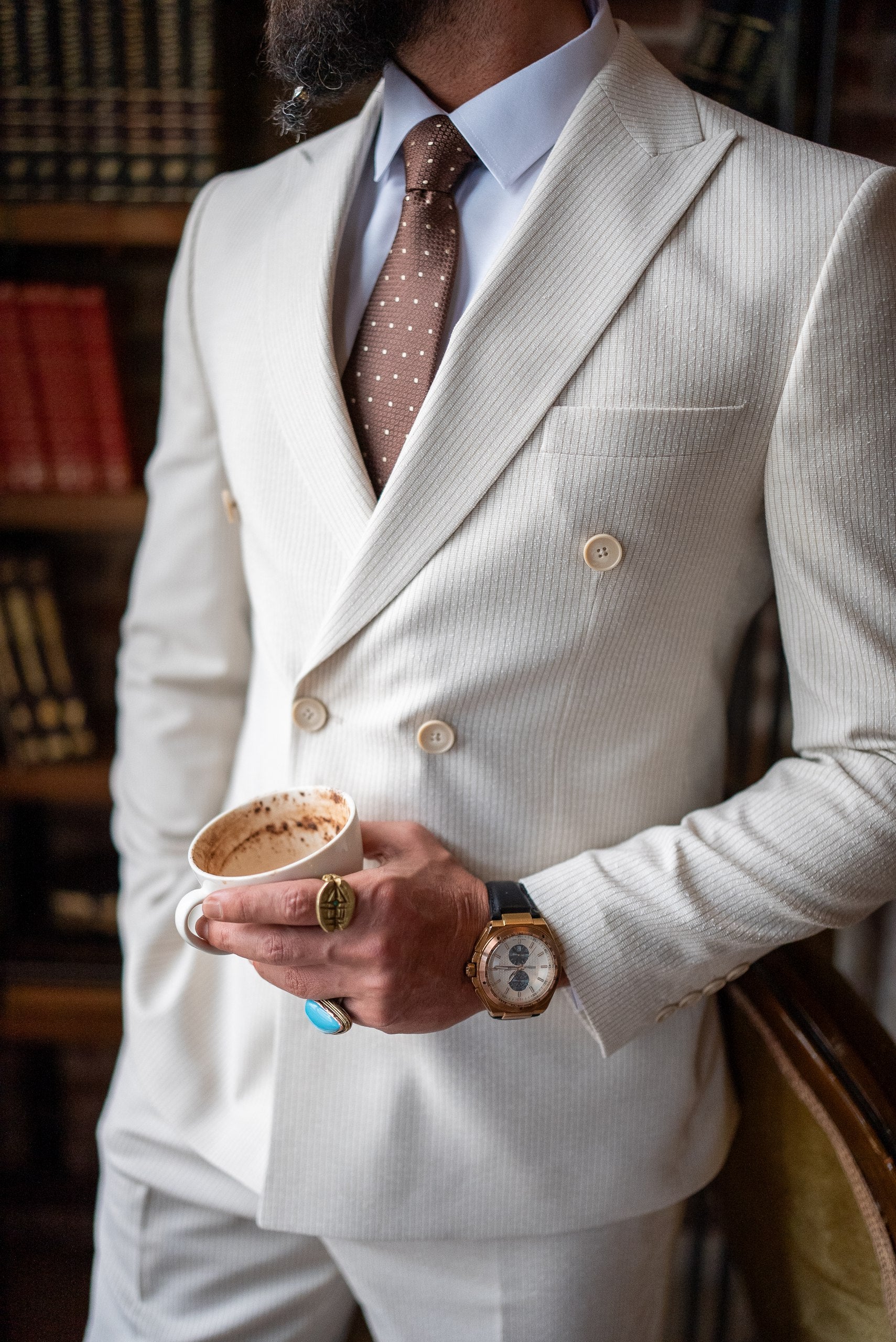 Stylish groom wearing beige double-breasted summer suit, side profile
