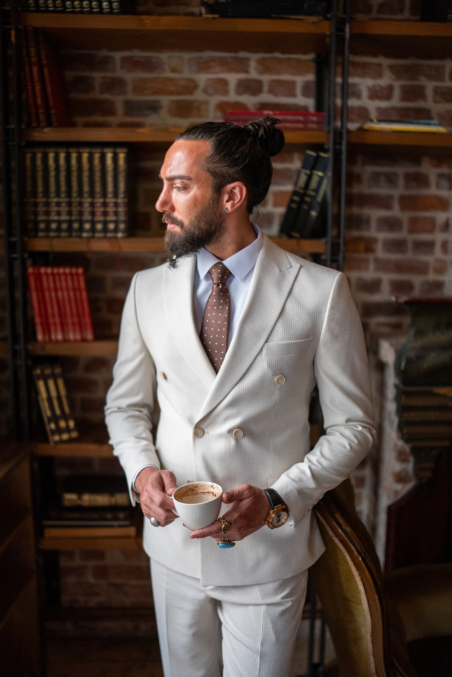 Detail shot of beige suit fabric and buttons with coffee cup