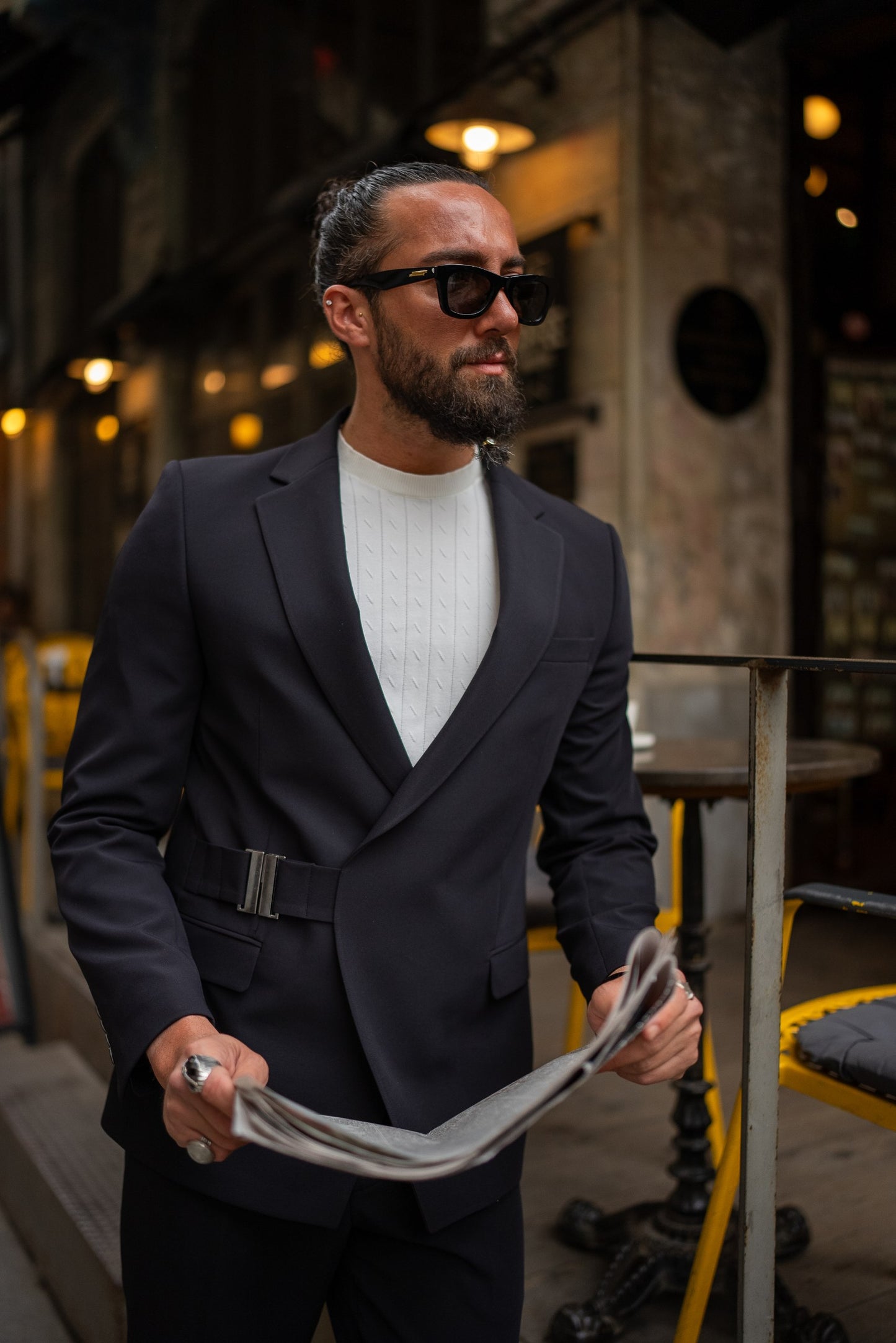 Fashion-forward black suit styled with sneakers for casual elegance