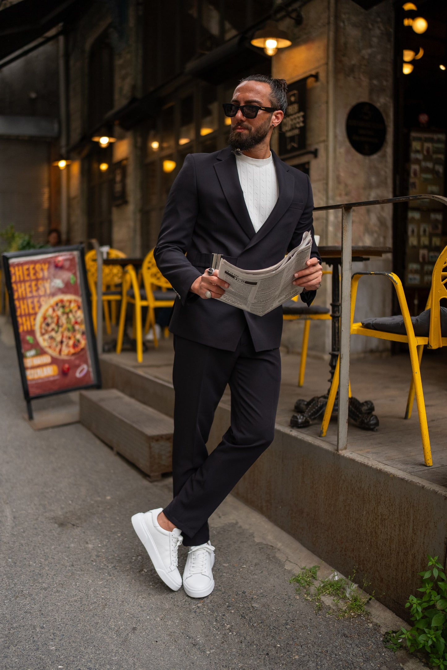 Lifestyle shot of black slim-fit suit styled with white knit shirt