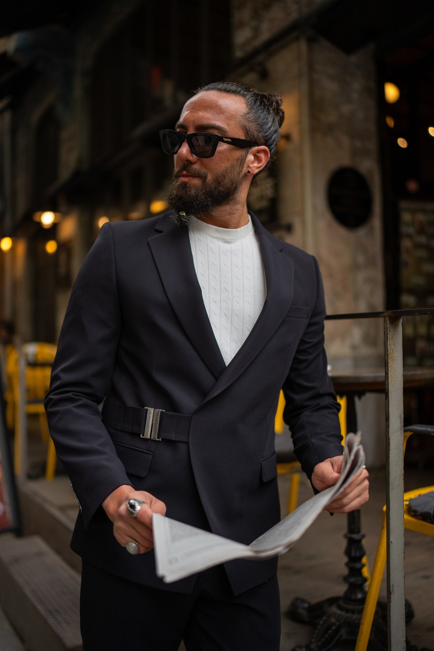 Close-up of black suit side buckle design and tailored details