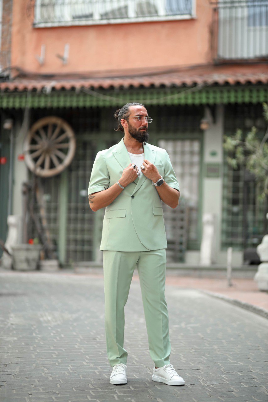 Close-up of men’s green tailored suit with short-sleeve design and modern fit.