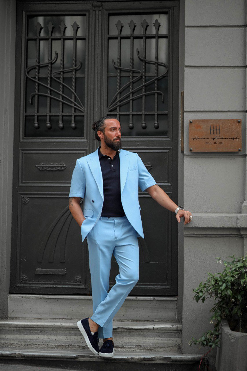 Stylish men’s light blue summer suit for outdoor events, paired with navy loafers, walking street