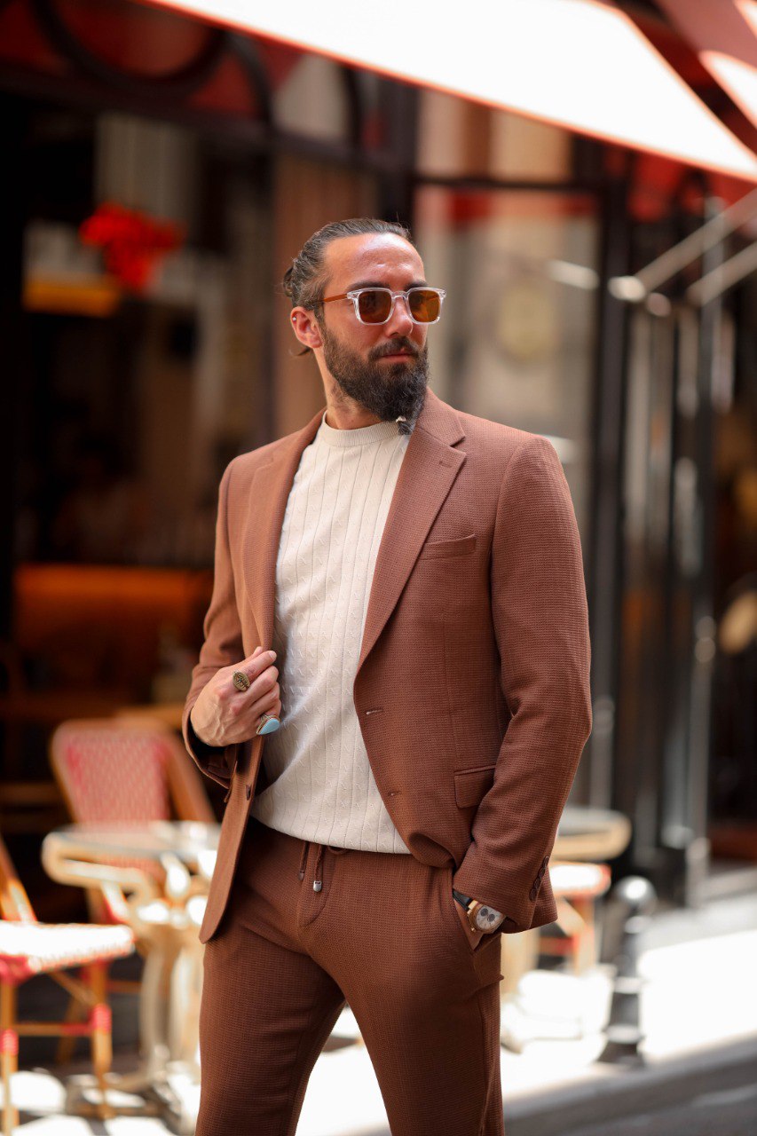 Men’s light brown slim fit summer suit styled with a knit top for smart casual wear.