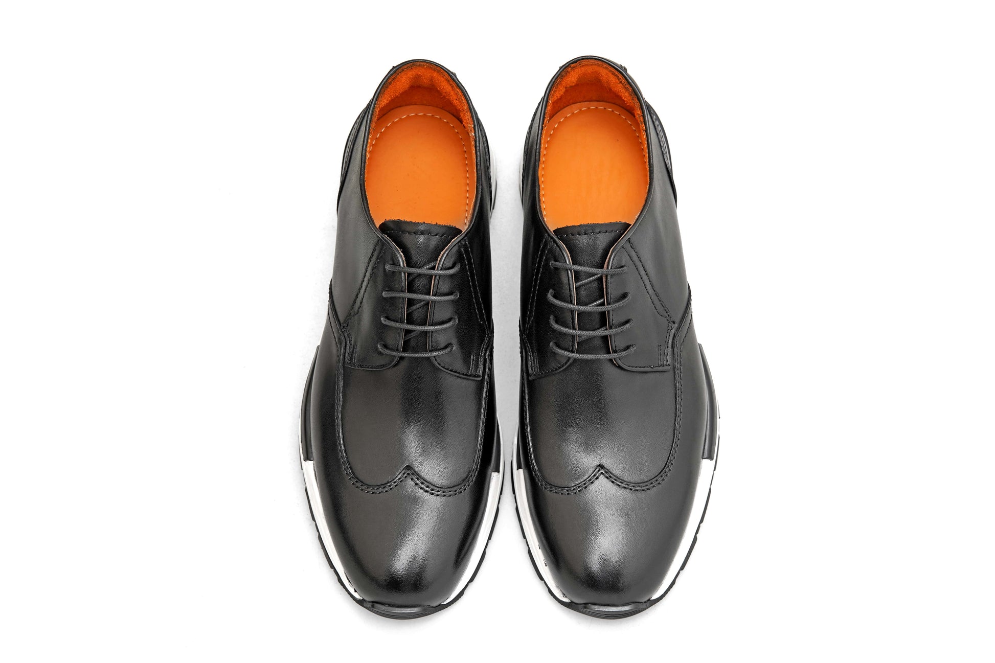 Black leather shoes with orange lining on a white background