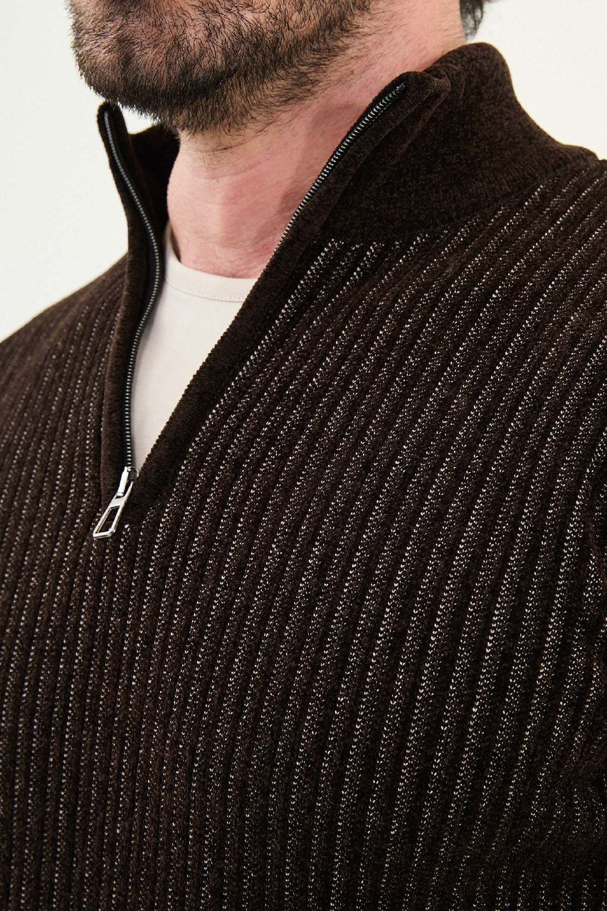 Close-up of a person wearing a brown ribbed sweater with a zipper.