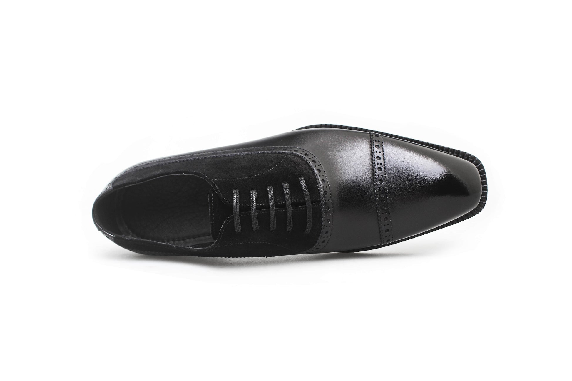 Close-up of men's black leather and suede oxfords with cap-toe detailing, showcasing a refined two-tone design perfect for formal attire.