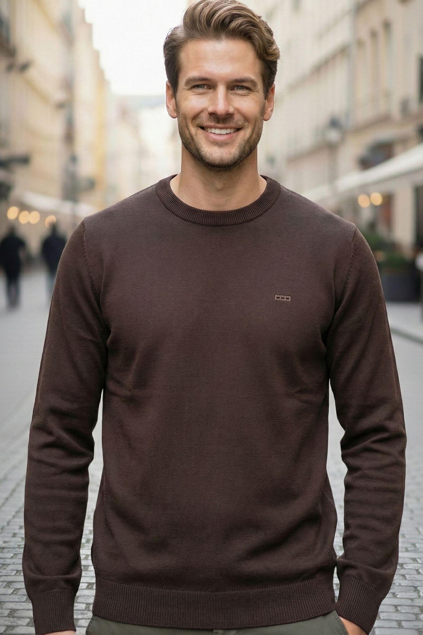Man wearing a brown sweater on a city street