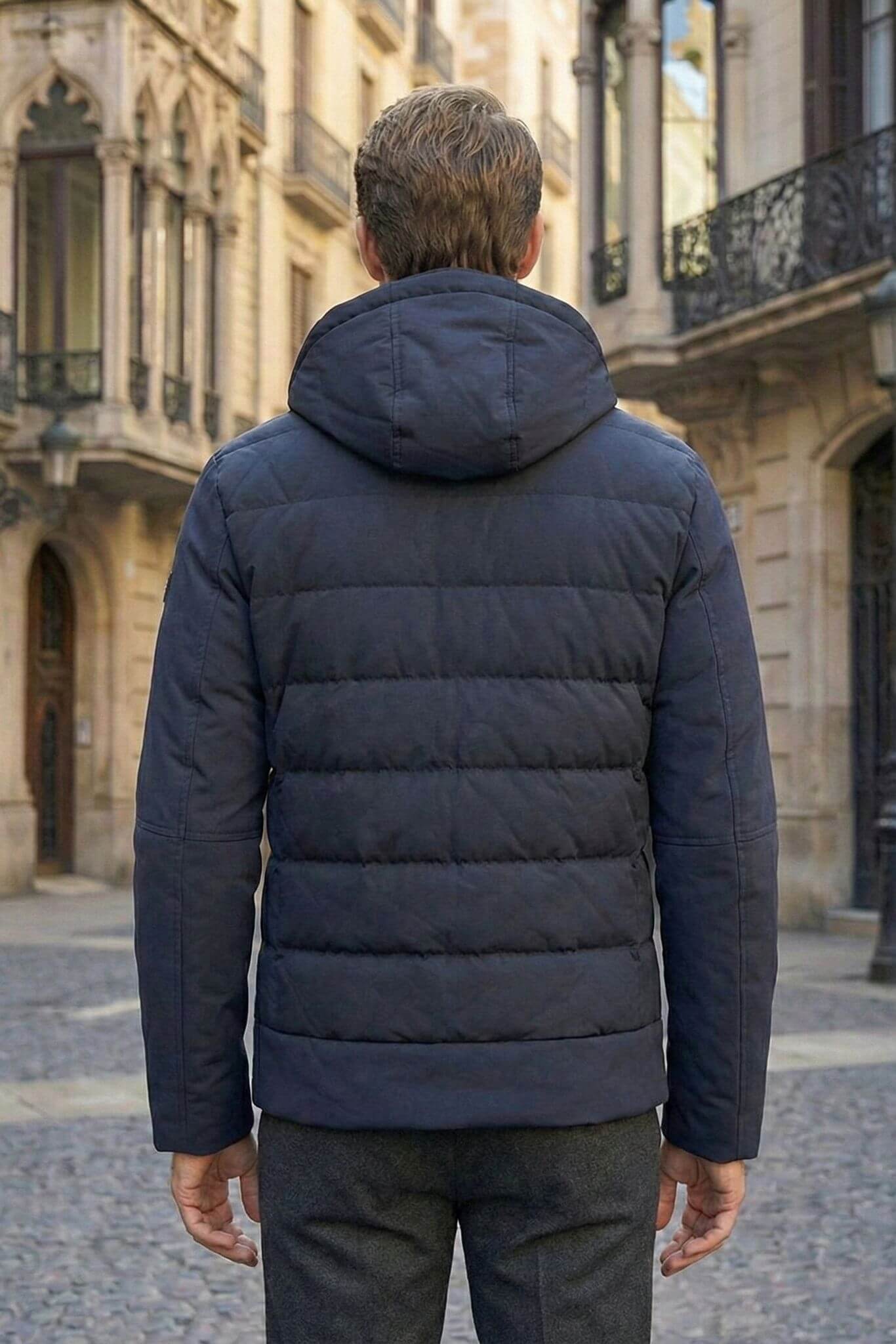 Man wearing a navy blue puffer jacket in an urban setting