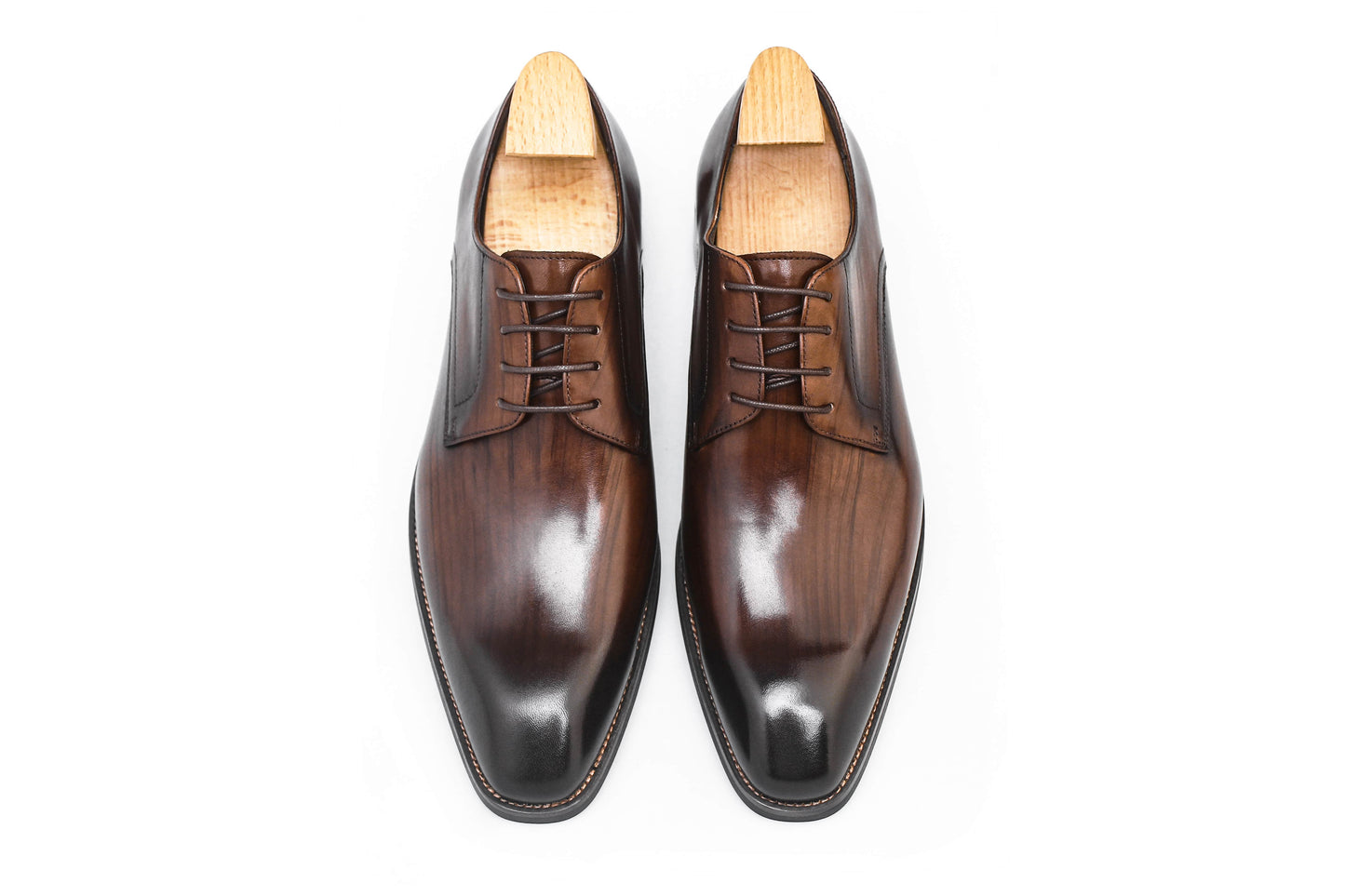 A pair of handcrafted brown leather Derby shoes for men, showcasing a polished finish and elegant design, perfect for formal wear and business occasions.