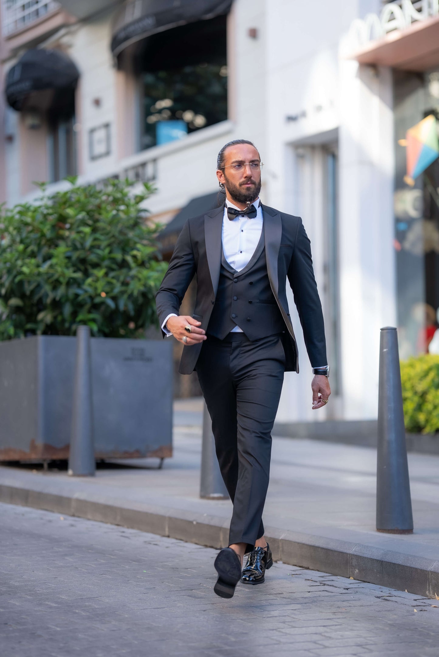 Elegant man wearing a black tuxedo with a bow tie, perfect for fall weddings and formal events.