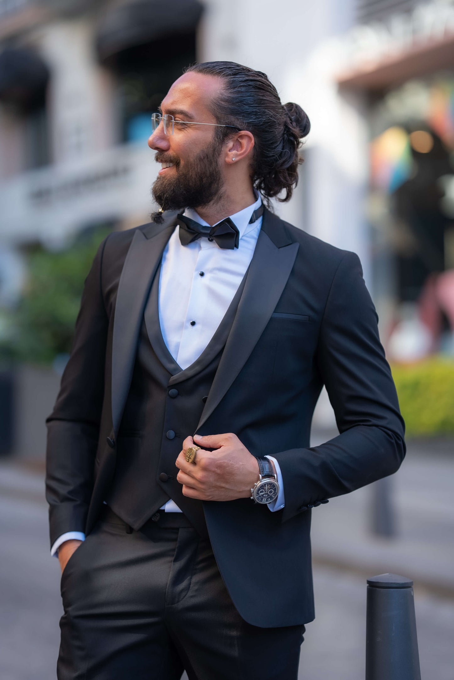 Elegant man wearing a black tuxedo with a bow tie, perfect for fall weddings and formal events.
