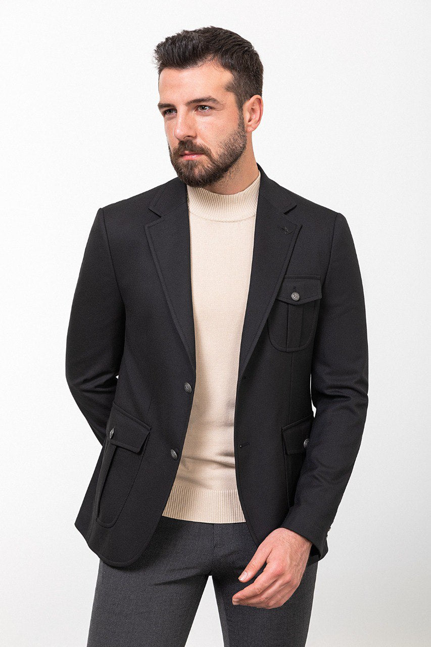 Man wearing a black blazer paired with a beige turtleneck.