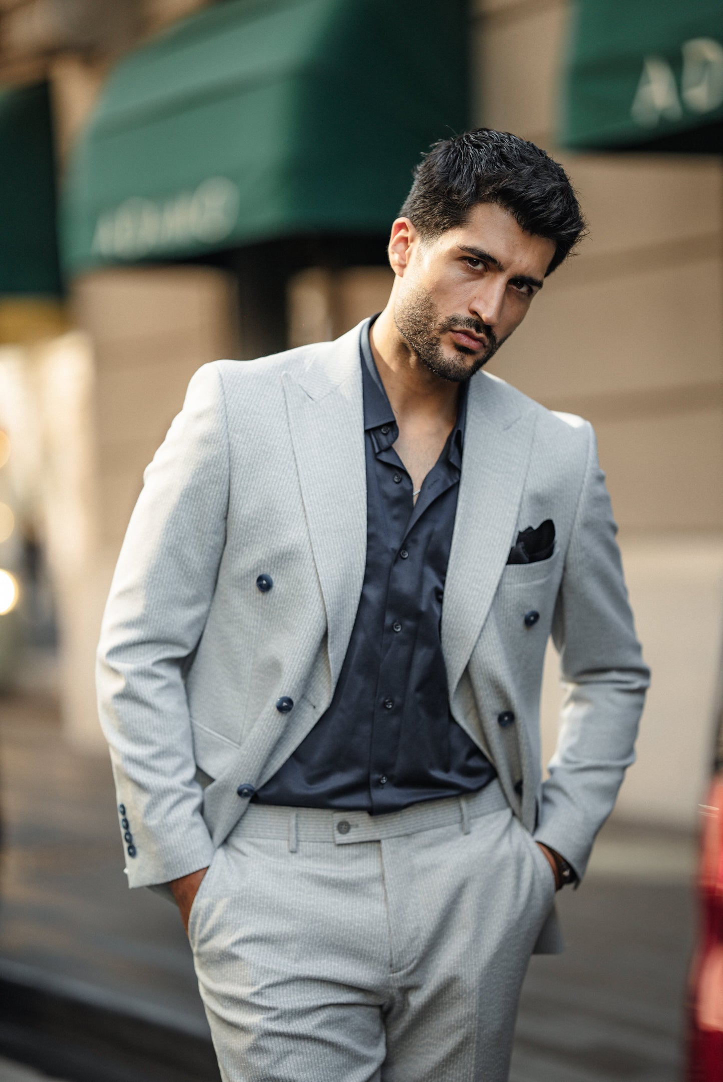 Lifestyle shot of man wearing blue tailored double-breasted suit in urban setting