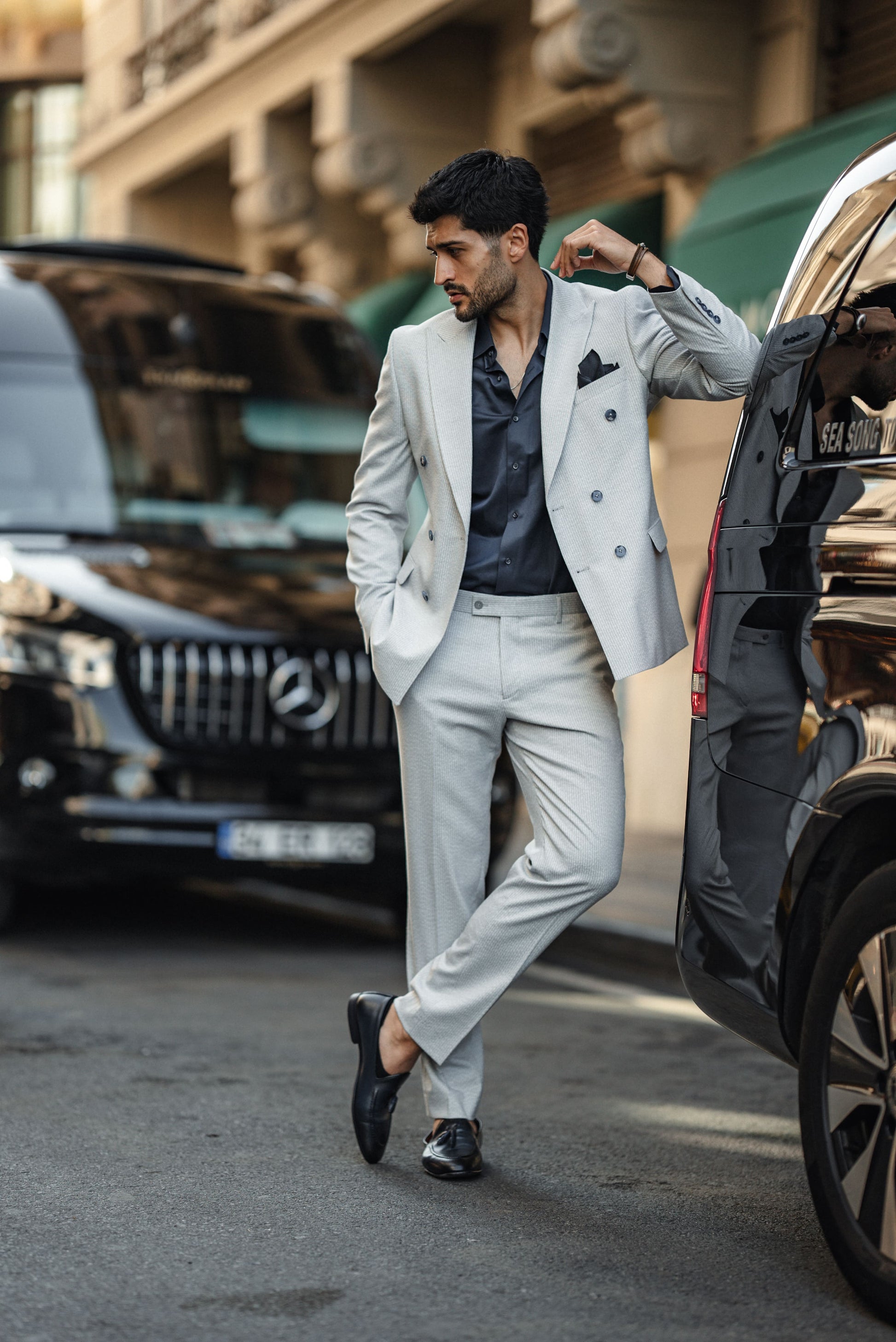 Lifestyle shot of man wearing blue tailored double-breasted suit in urban setting