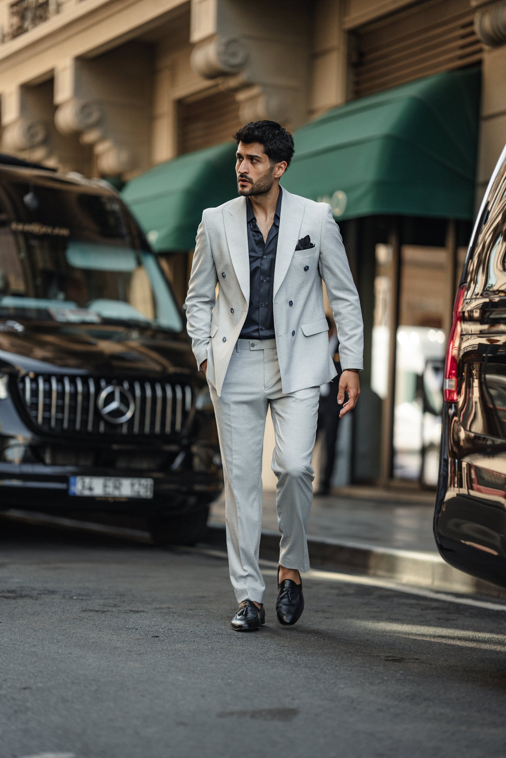 Lifestyle shot of man wearing blue tailored double-breasted suit in urban setting”