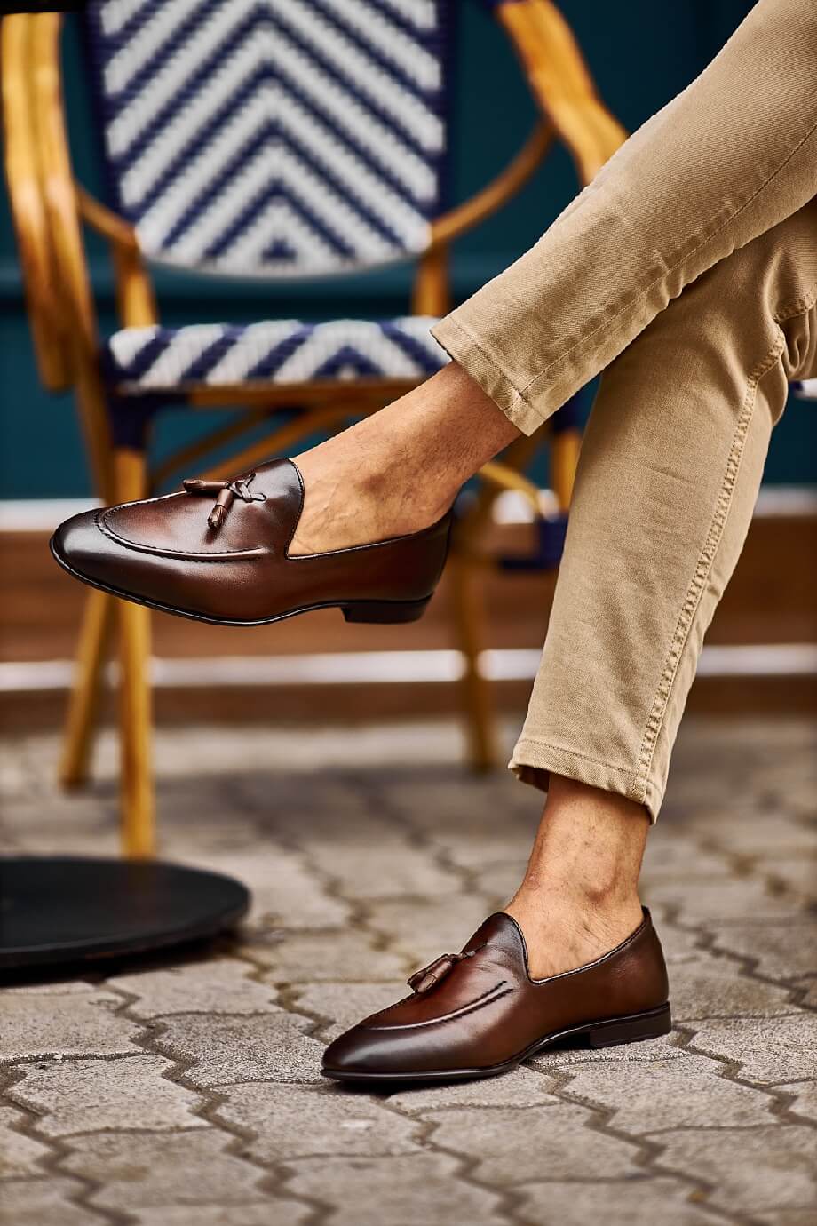 Close-up of stylish brown tassel loafers paired with beige pants, perfect for a casual yet refined look.