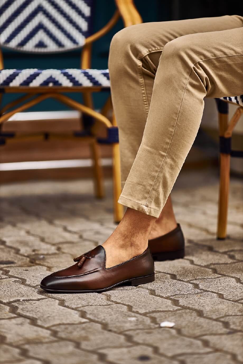 Close-up of stylish brown tassel loafers paired with beige pants, perfect for a casual yet refined look.
