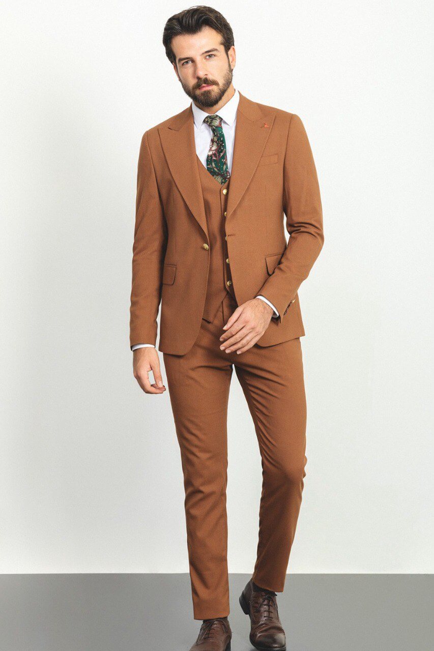 Man wearing a camel 3-piece suit with a white shirt and patterned tie.