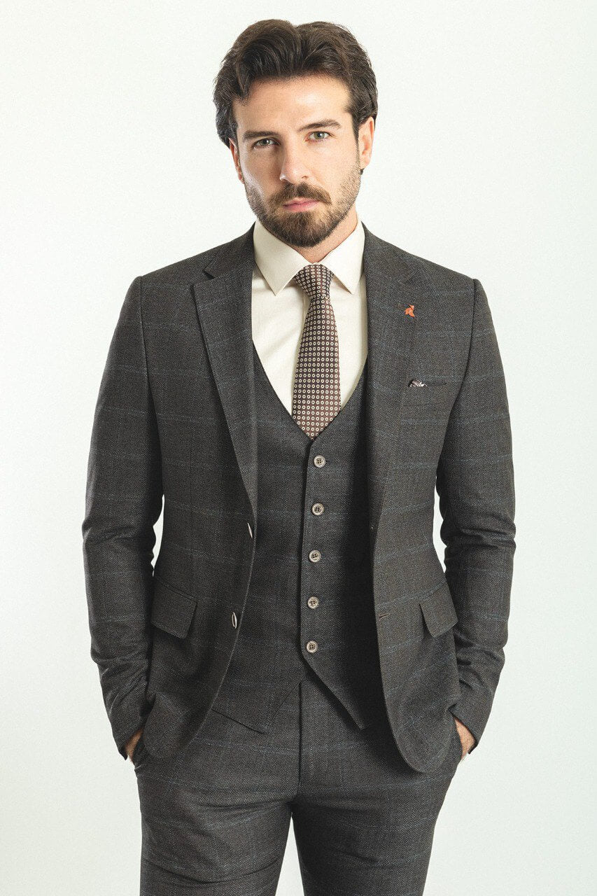 Man in a dark blue patterned 3-piece suit, showcasing elegance and style.