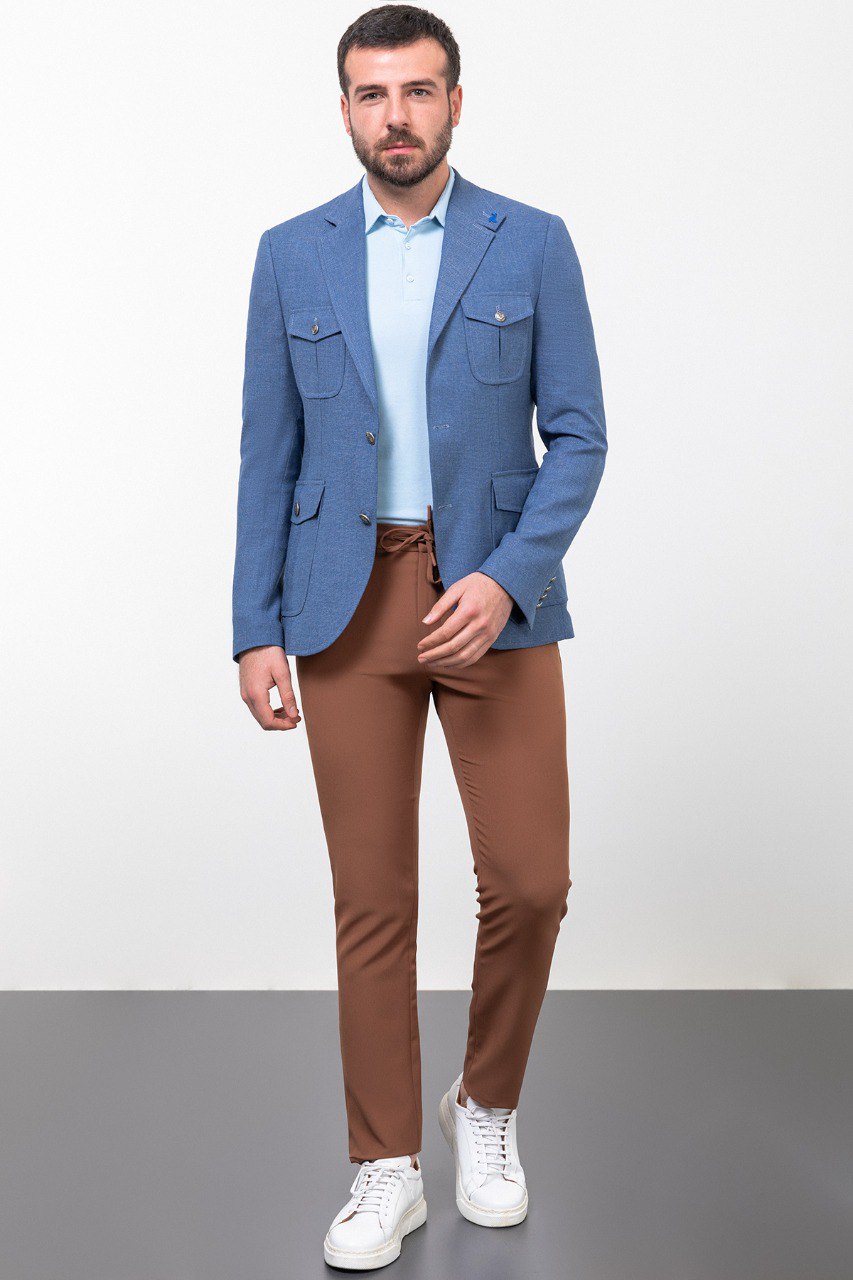 Man wearing a blue blazer with brown trousers and white sneakers, perfect for smart-casual or business-casual attire.