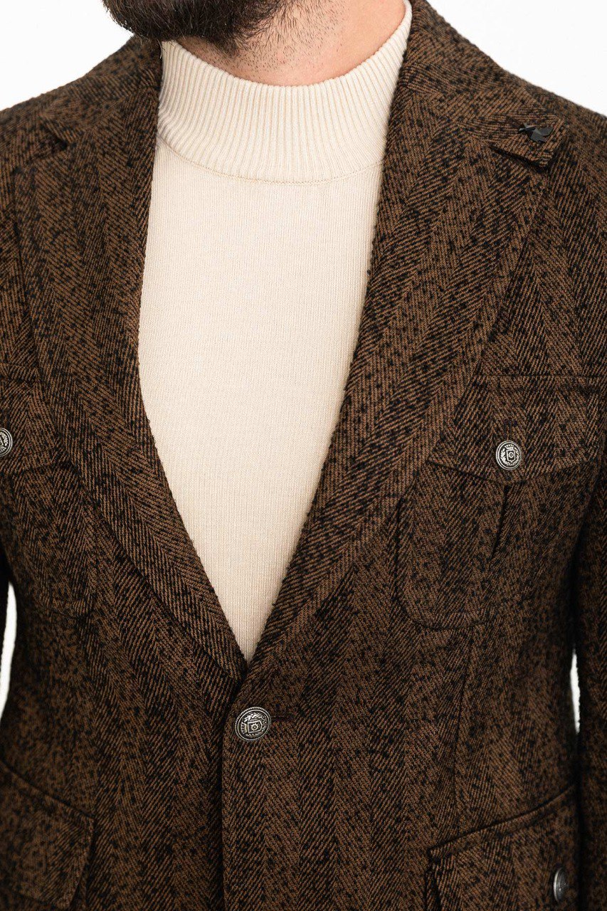 Man dressed in a brown textured blazer with a beige turtleneck, showcasing a modern, sophisticated smart-casual outfit.