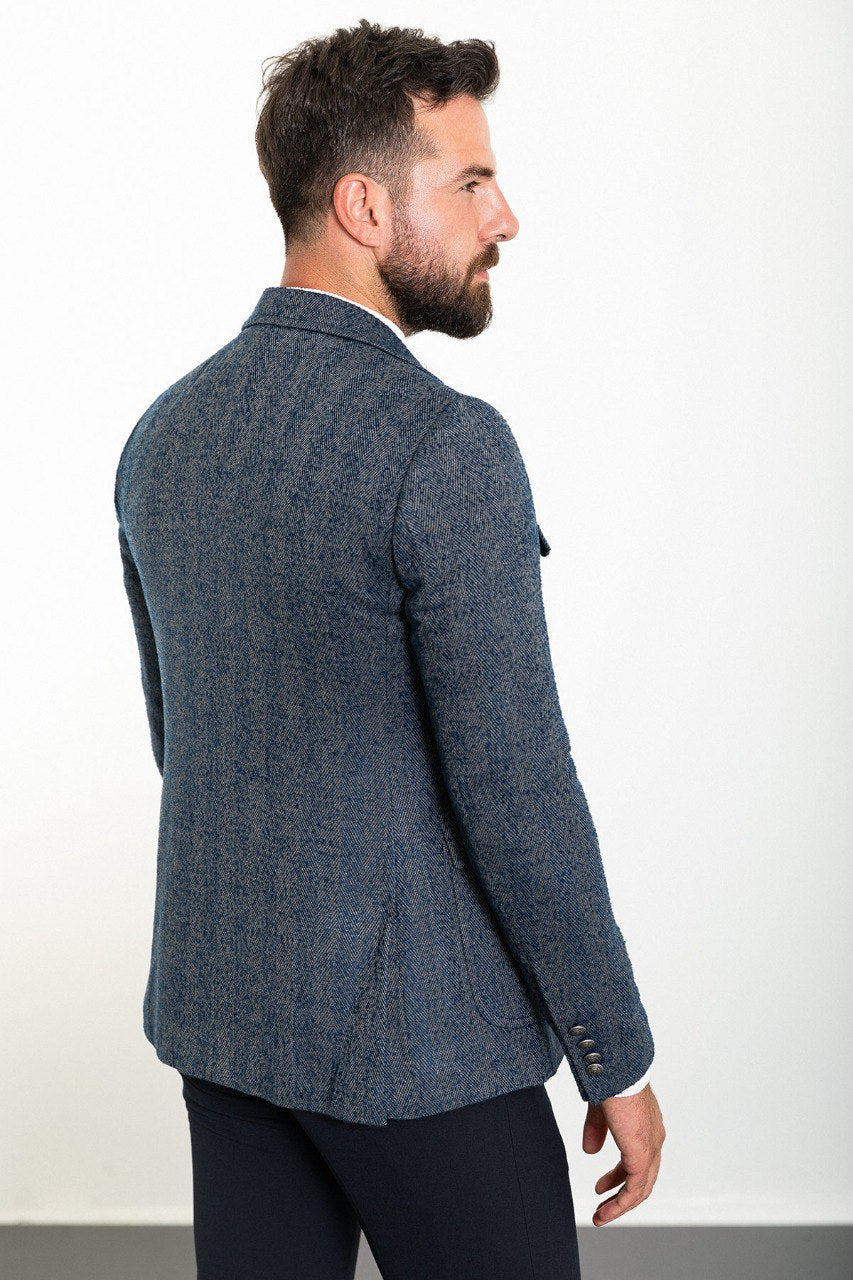 Man wearing a textured blue blazer with a white turtleneck, showcasing a smart-casual look perfect for fall and winter fashion.