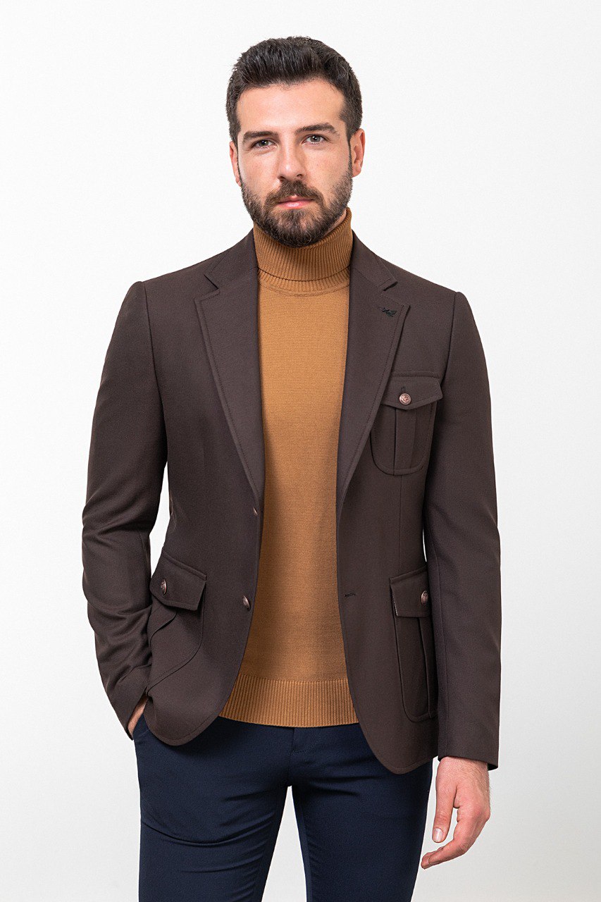 Man wearing a dark brown blazer with a tan turtleneck and navy trousers, styled for a smart-casual autumn look.