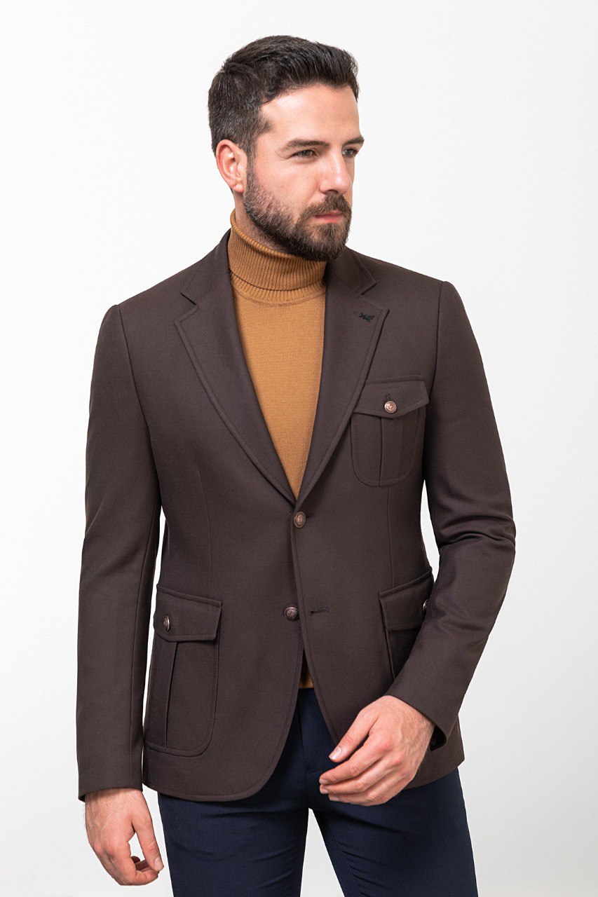 Man wearing a dark brown blazer with a tan turtleneck and navy trousers, styled for a smart-casual autumn look.