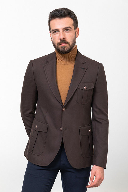 Man wearing a dark brown blazer with a tan turtleneck and navy trousers, styled for a smart-casual autumn look.