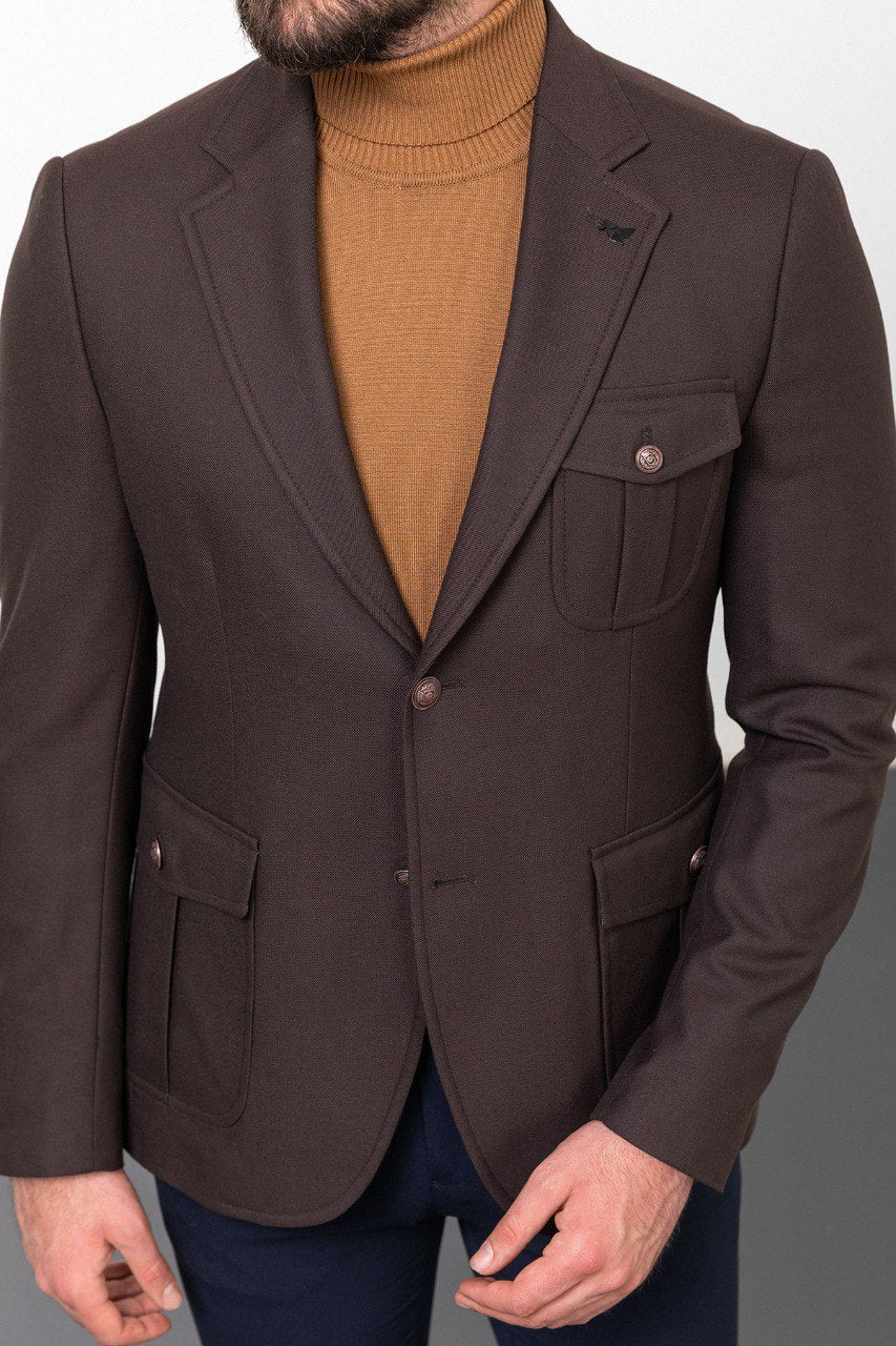 Man wearing a dark brown blazer with a tan turtleneck and navy trousers, styled for a smart-casual autumn look.