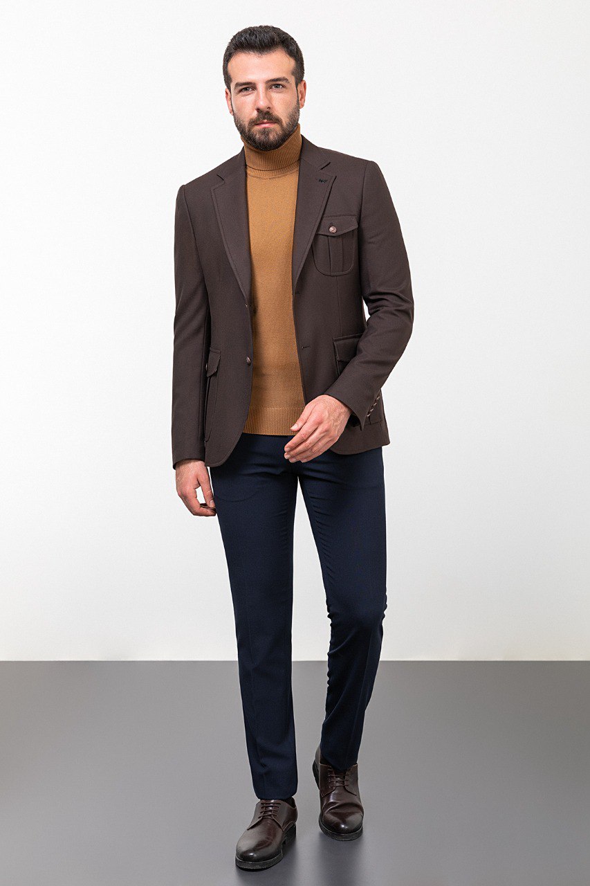 Man wearing a dark brown blazer with a tan turtleneck and navy trousers, styled for a smart-casual autumn look.
