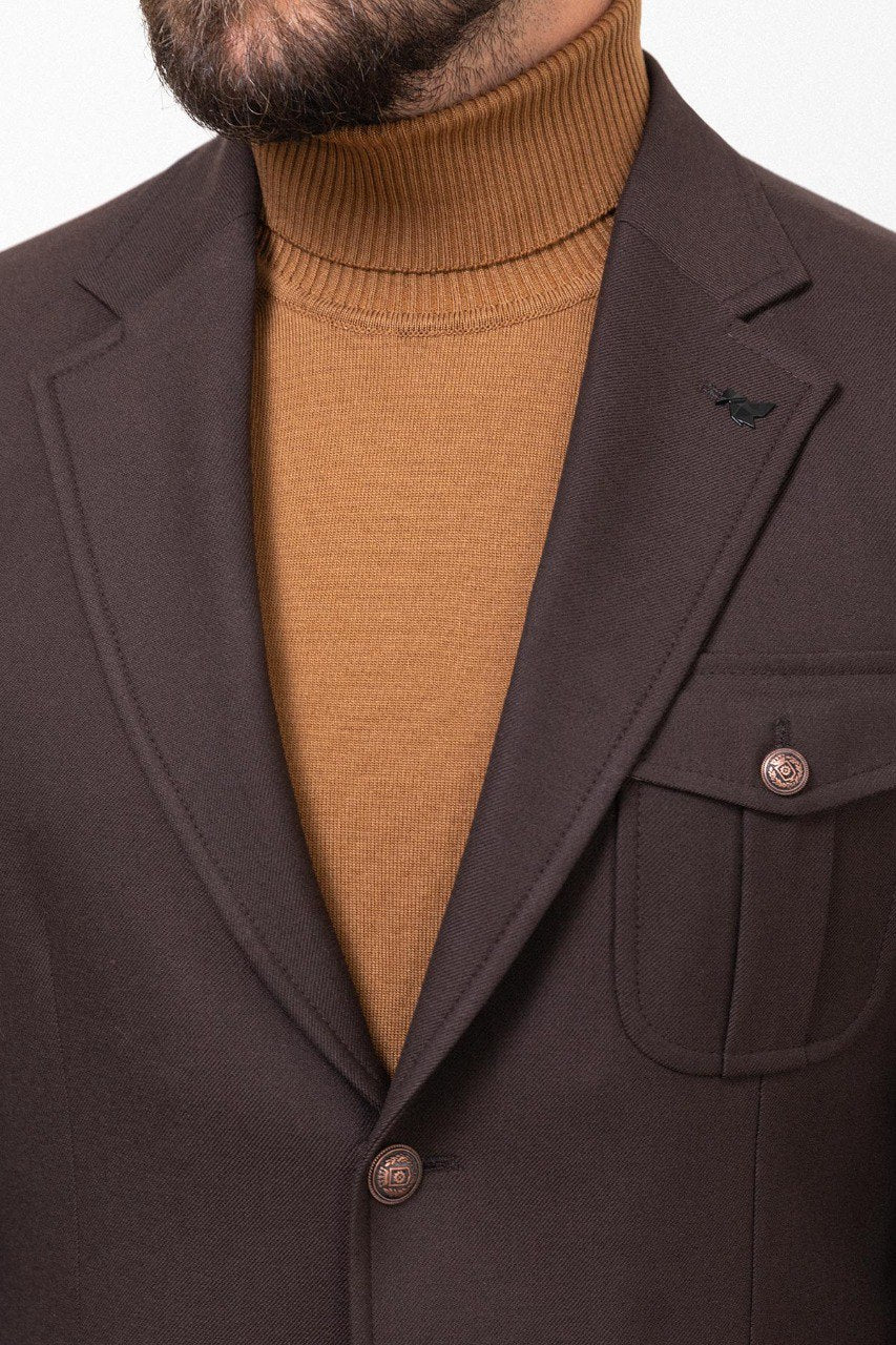 Man wearing a dark brown blazer with a tan turtleneck.