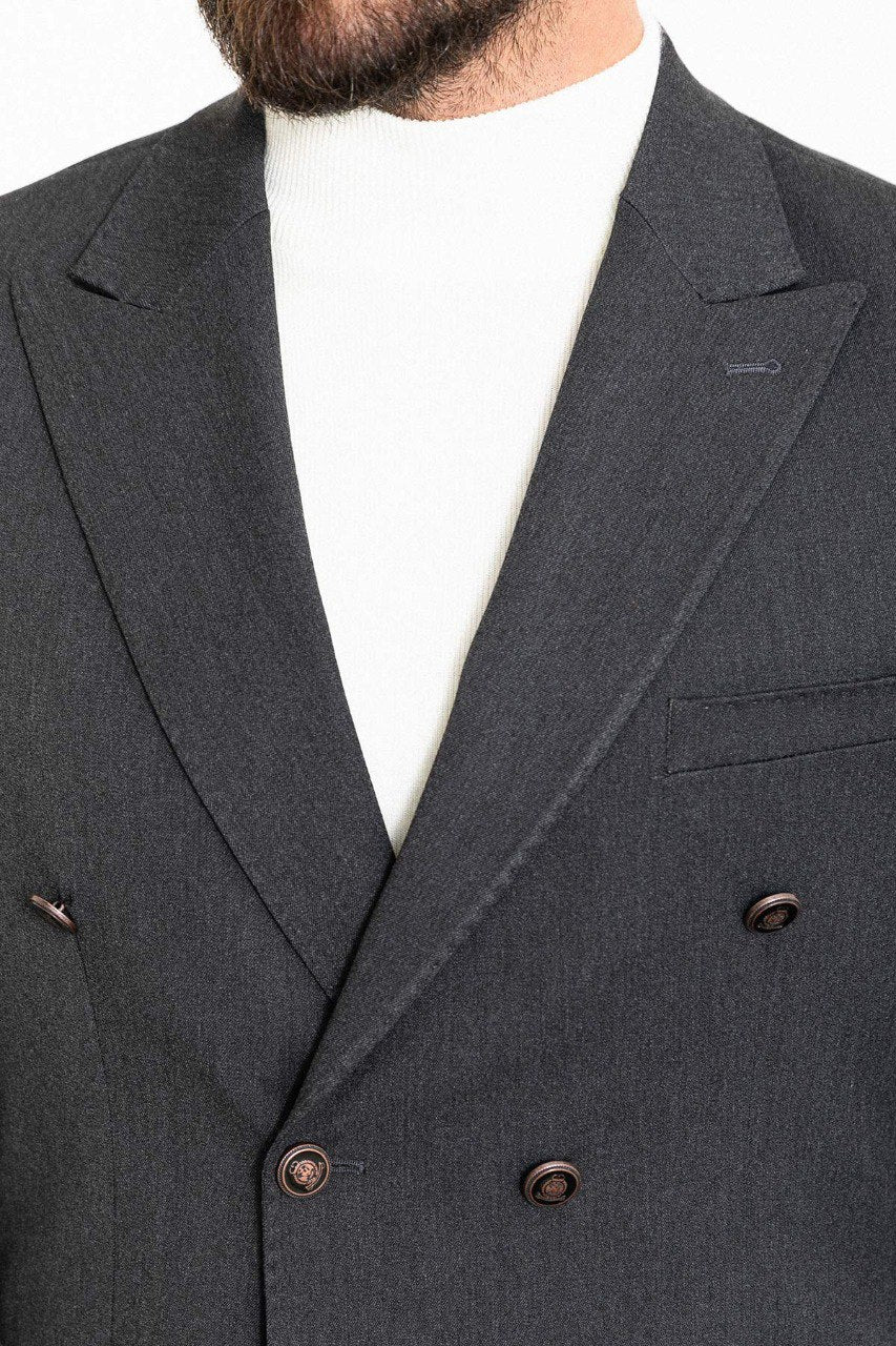 "Man wearing a gray double-breasted blazer paired with a white turtleneck.