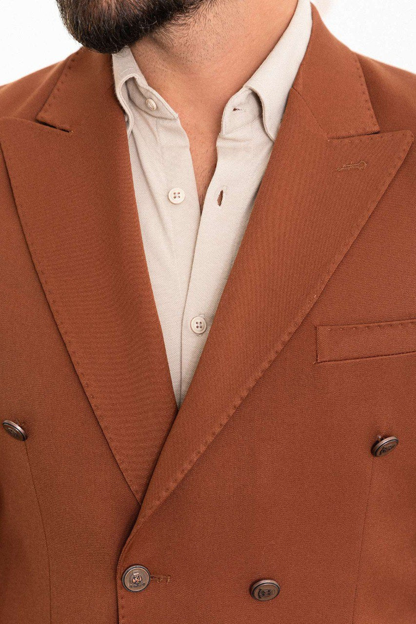 Man in a stylish brown double-breasted blazer paired with a beige shirt.
