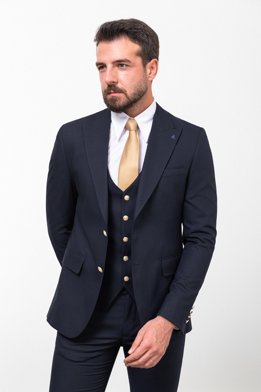 Man wearing a navy blue 3-piece suit with a gold tie.