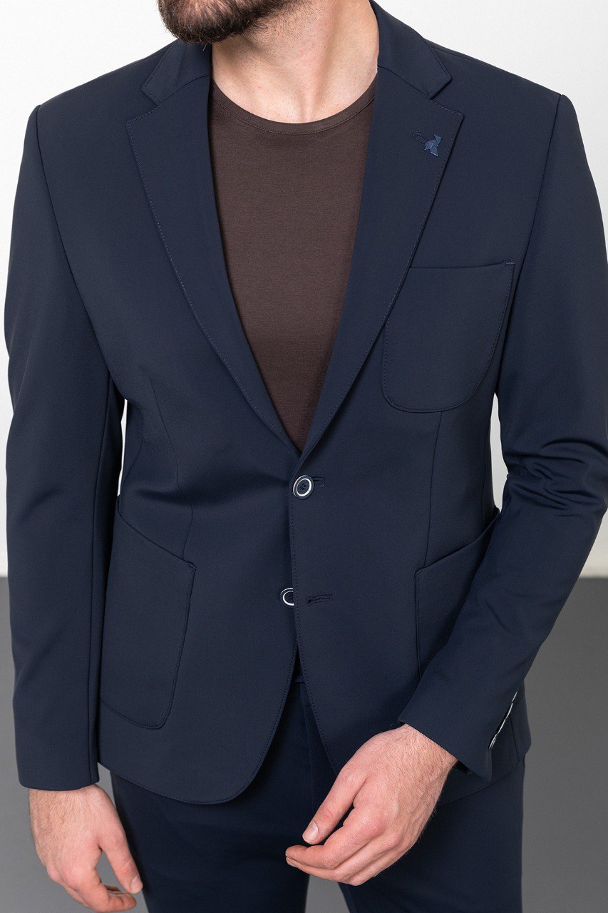 Man wearing a navy blue leisure suit with white sneakers.