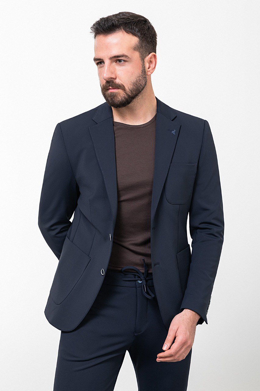 Man wearing a navy blue leisure suit with white sneakers.