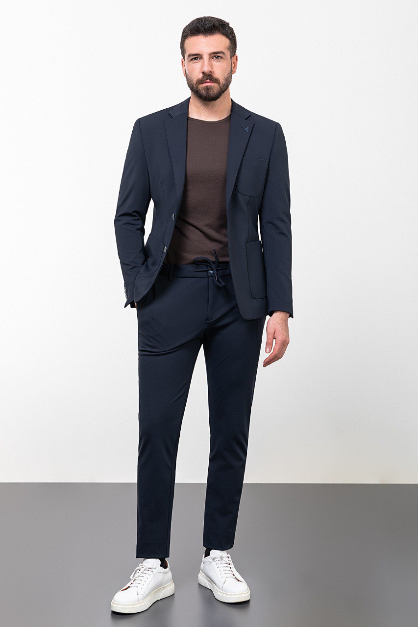 Man wearing a navy blue leisure suit with white sneakers.