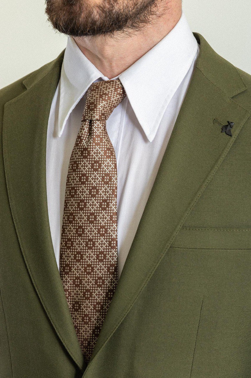 Man wearing an Olive Grove Suit with a sharp pointed collar, flap pockets, and a slim fit, perfect for weddings and business engagements.