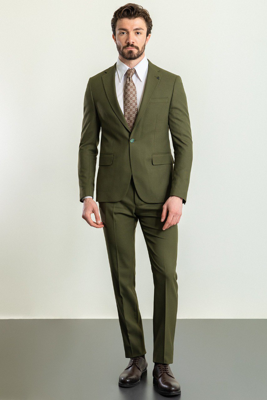 Man wearing an Olive Grove Suit with a sharp pointed collar, flap pockets, and a slim fit, perfect for weddings and business engagements.