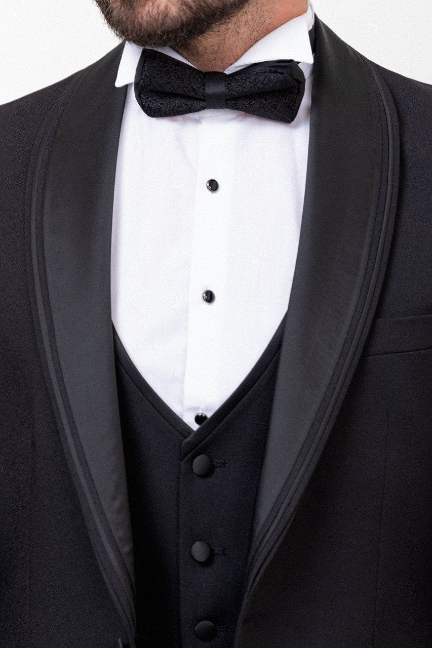 Man wearing a black 3-piece suit with a bow tie.